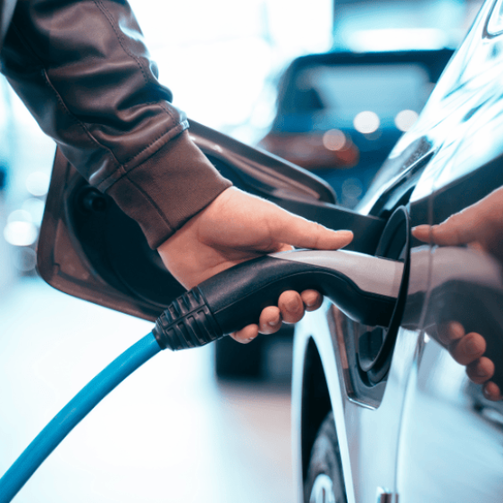 Personne qui branche une prise électrique à un véhicule.