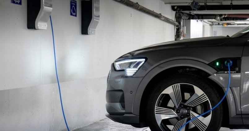 Voiture électrique se rechargeant à une borne de recharge dans un parking souterrain
