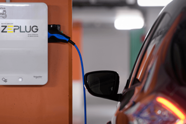 Véhicule électrique citadin se rechargeant à une borne de recharge Zeplug