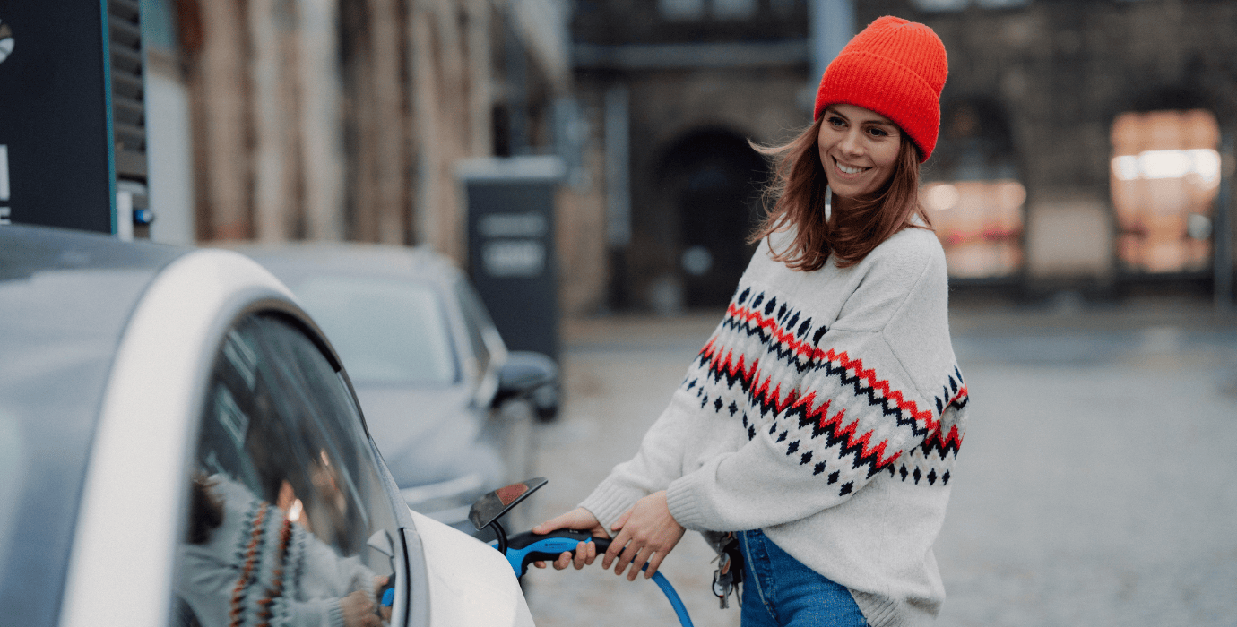 Femme branchant son véhicule électrique dans la rue