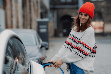 Femme branchant son véhicule électrique dans la rue