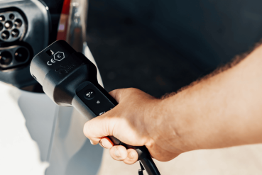 Homme souhaitant recharger son véhicule électrique avec un cordon de recharge