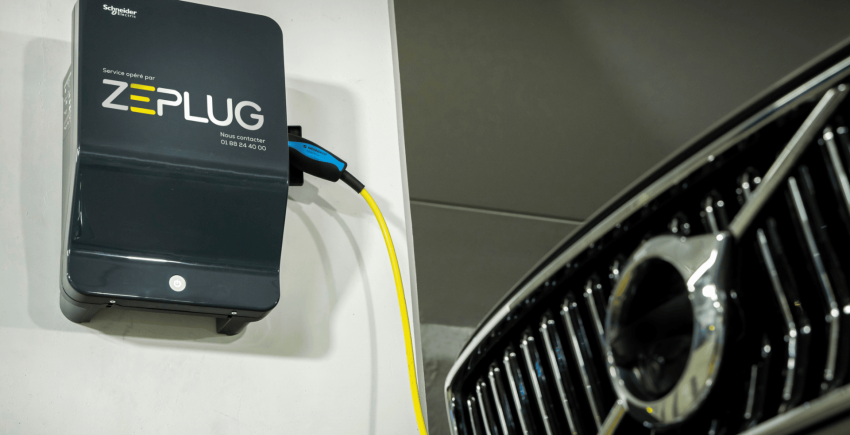 Véhicule électrique branché à une borne de recharge noire