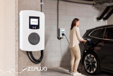 Borne de recharge dans un parking sous terrain. Femme branche son véhicule en arrière plan.